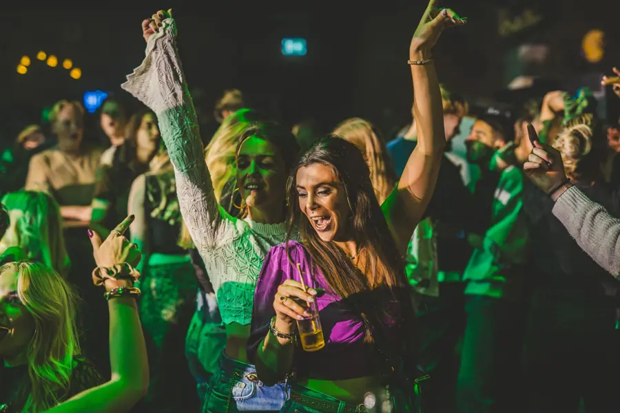 Vriendinnen dansen met de handen omhoog