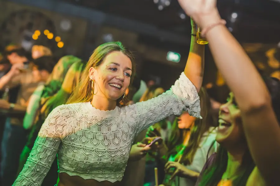 Vrouw in kanten top danst lachend
