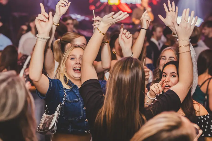 Vrouwen dansen met de handen omhoog